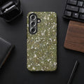 Phone case with a green moss and pebble pattern, featuring a triple camera array.